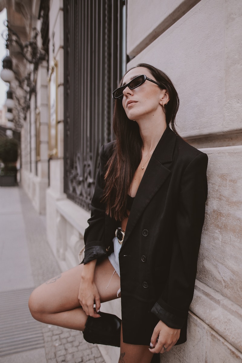 A woman leaning against a wall with her legs crossed
